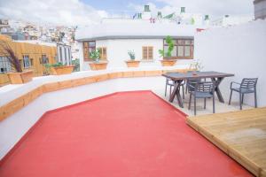 大加那利岛拉斯帕尔马斯Sweet Stays的阳台的红地毯,配有桌椅