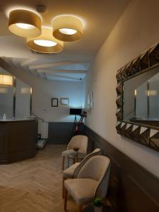 Chauchina马里尼托酒店的一间设有两把椅子和镜子的等候室