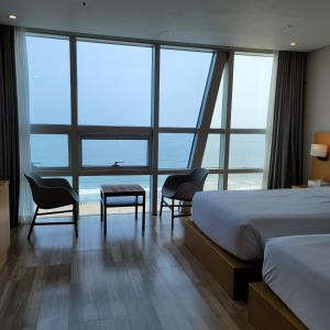釜山海云台MS酒店的酒店客房带一张床、一张桌子和椅子