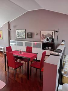博拉泰La mansarda di Mi&Lo junior suite的一间用餐室,配有红色的桌子和椅子