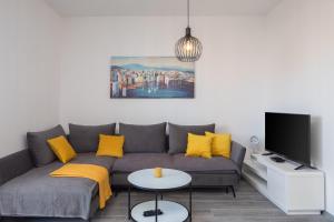 斯普利特New luxury 3-bedroom penthouse with huge terrace的客厅配有灰色的沙发和黄色的枕头。
