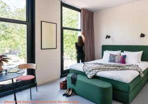 鹿特丹Hotel Unplugged的一间卧室配有一张床和一张绿色沙发