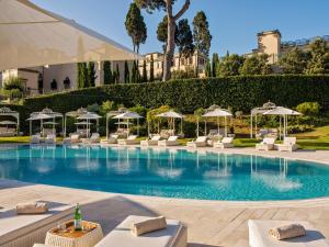 罗马Villa Agrippina Gran Meliá – The Leading Hotels of the World的一个带白色躺椅和遮阳伞的游泳池