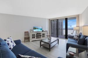 马可岛South Seas Tower 4-1204的客厅配有蓝色的沙发和电视