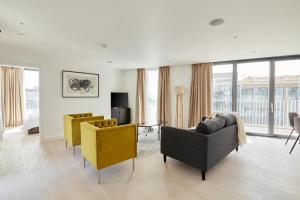 伦敦Southwark by Q Apartments的大楼内客厅配有沙发和黄色椅子
