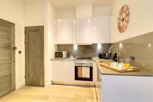 斯劳La Casa Suites Slough的厨房配有白色橱柜和台面