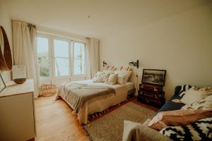 汉堡Am Alsterpark的一间卧室配有一张床、一张沙发和一个窗口
