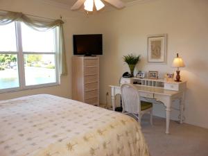 马可岛265 Villas at Waterside, Unit 201的一间卧室配有一张床、一张书桌和一台电视
