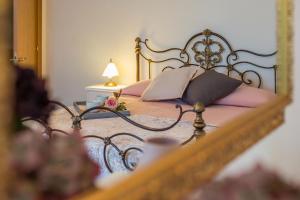 佩尔戈拉Casale Lucy的一间卧室配有一张带粉红色枕头和镜子的床