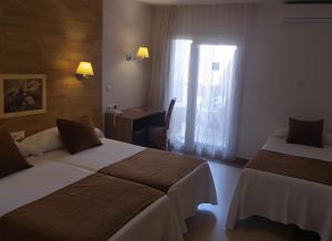 瓜尔达马尔·德尔·塞古拉瓜尔达马尔酒店的酒店客房设有两张床、一张书桌和一个窗户。
