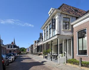 霍尔沃德Zee van Tijd Holwerd的街道上拥有建筑和汽车的街道