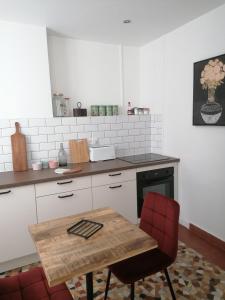 勒布伊Le 43-3 avec sauna privatif的厨房配有木桌和红色椅子