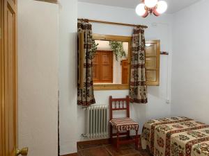 卡皮雷拉Hostal Atalaya en Capileira CB的卧室配有床、椅子和窗户。