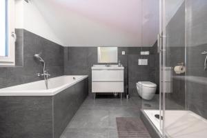 厄茨Urlaubsplatzl Appartements的带浴缸、卫生间和盥洗盆的浴室