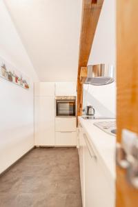 厄茨Urlaubsplatzl Appartements的厨房配有白色橱柜和微波炉