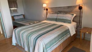 Jemseg杰姆塞格湖景汽车旅馆的一间卧室配有带条纹被子的床