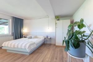 瑞汀Strandkoje Wohnung 5的一间卧室配有一张床和盆栽植物