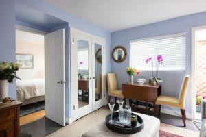 洛杉矶The Green Ginger Guest House的一间带蓝色墙壁的卧室和一间带桌子的用餐室