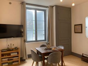 圣莱奥纳尔德诺布拉La Cour Pavée, T2 lumineux, cosy, confort 55 m2的客厅配有桌椅和电视。