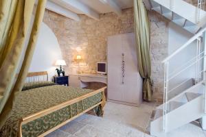 阿尔贝罗贝洛Le Alcove - Luxury Hotel nei Trulli的一间卧室配有一张床,房间设有楼梯