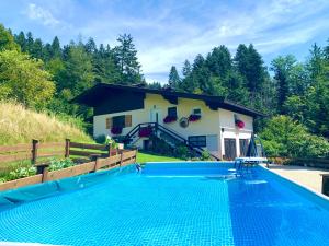蒂罗尔州圣约翰Sunnseit Lodge - Kitzbüheler Alpen的别墅前设有游泳池
