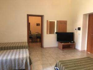 罗萨诺Hostels Euro Mediterraneo的客房设有两张床和一台平面电视。