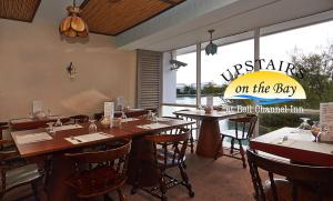 自由港市Bell Channel Inn Hotel的餐厅设有桌椅和大窗户。