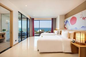 岘港Da Nang - Mikazuki Japanese Resorts & Spa的卧室配有一张白色大床,享有海景