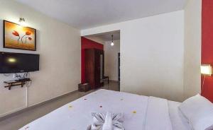 蒙纳Deshadan Mountain Resort -The highest resort in Munnar的卧室配有白色的床和平面电视。