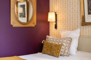 拉波勒勒圣特克里斯托弗酒店的一间卧室设有紫色的墙壁和一张带枕头的床