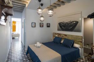 圣玛丽亚港Casa Portus Gaditanus s XVIII Patio Andaluz的一间卧室配有蓝色的床和蓝色枕头