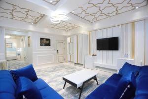 塔什干Reikartz Amirun Tashkent的客厅配有蓝色的沙发和电视