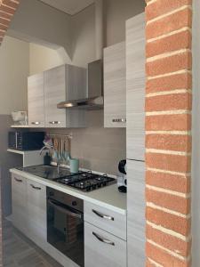 蒂勒尼亚Casina Summer的厨房配有白色橱柜和炉灶。