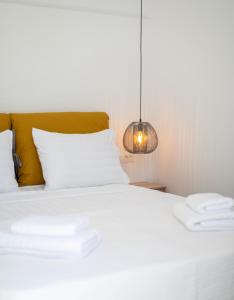 米克诺斯城Mytheo的卧室配有白色的床和灯