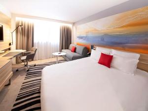 克莱蒙费朗克莱蒙费朗诺富特酒店的酒店客房设有一张大床和一张书桌。