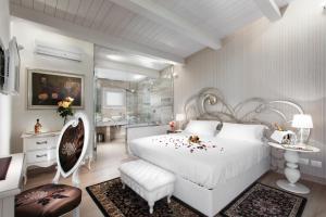 里米尼王侯精品度假酒店及水疗中心的一间带白色床的卧室和一间浴室