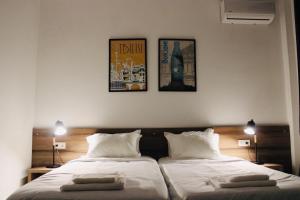 高尼奥Citro Villa的卧室配有两张床,墙上挂有两张照片
