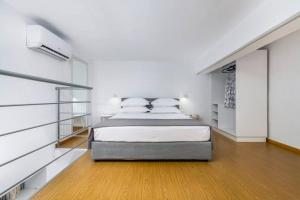阿达玛斯CASA ANNA LOFT Boutique House with Full Sea View的卧室配有一张带白色墙壁和木地板的大床