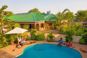 维多利亚瀑布Dzimbahwe Guest Lodge的一群人坐在一个游泳池前