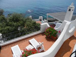 圣费利切-奇尔切奥朋塔罗萨酒店的阳台配有白色椅子和鲜花,享有海景。