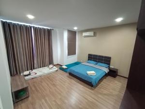 古晋Triple Z Homestay Kuching - LANDED 14 PAX的一间卧室设有蓝色的床和大窗户