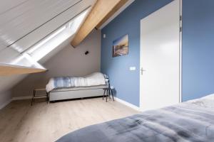 韦默尔丁厄Chezeehoeve - Wemeldinge的一间拥有蓝色墙壁的卧室、一张床和窗户