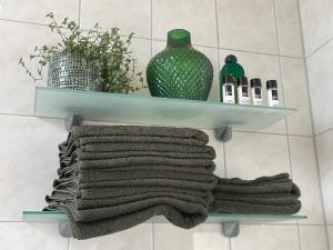 马斯特里赫特PetitGrandeur的浴室里的架子,带毛巾和花瓶