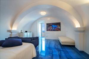 滨海波利尼亚诺Hotel Grotta Palazzese的一间设有两张床的客房,铺有蓝色的地板