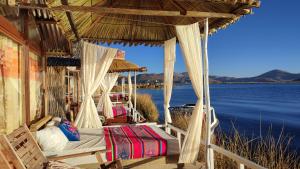 普诺Titicaca Aruntawi Lodge Peru的水景门廊内的一张床位