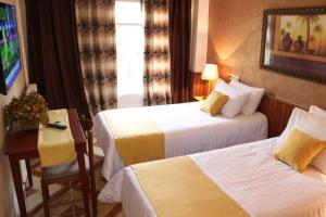 巴特纳Hotel el Hayat的酒店客房设有两张床和一张桌子。