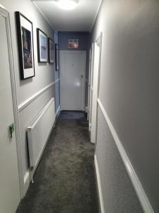 绍斯波特The Braemar Southport的走廊,走廊通往带门的房间