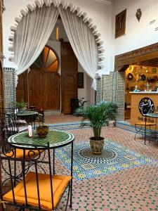 得土安Riad & Café culturel BAB EL FAN的大堂的桌子和植物