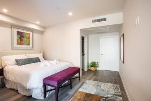 圣地亚哥One Bedroom Apartment with San Diego Downtown View的卧室配有一张白色大床和紫色长凳