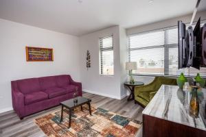 圣地亚哥Prime Location - Awesome View -1 bedroom Apartment的客厅配有紫色沙发和桌子